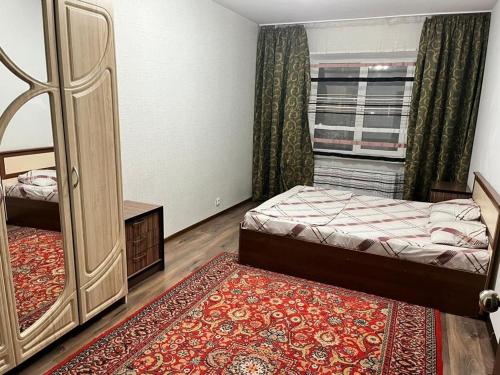 a bedroom with a bed and a large mirror at Квартира in Karagandy