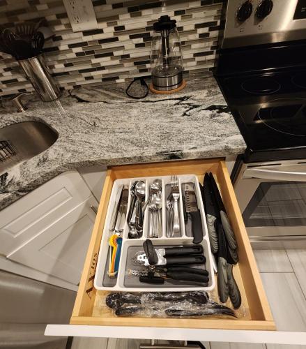 a kitchen counter with a drawer full of utensils at The Relaxation Oasis in Philadelphia