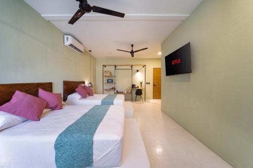 Cette chambre dispose de 2 lits et d'une télévision murale. dans l'établissement Hotel Bindani’, à Santa Cruz Huatulco