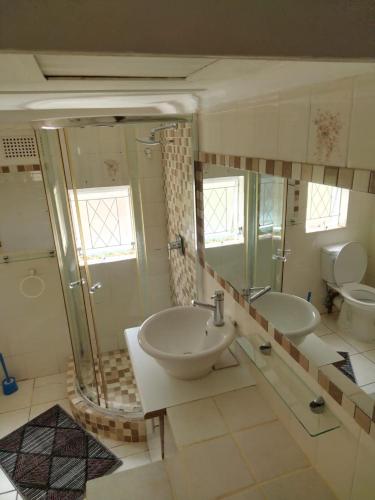 a bathroom with two sinks and a shower and a toilet at Comrades Oasis Guest House in Pietermaritzburg