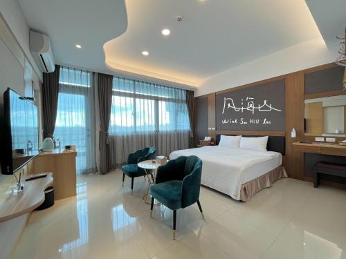 Habitación de hotel con cama, mesa y sillas en Wind Sea Hill Inn, en Hengchun