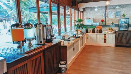 a large kitchen with a counter with many windows at Sylvia Hotel & Resort Komodo in Labuan Bajo