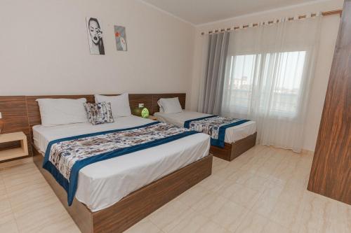 a hotel room with two beds and a window at Andalusia Blue Beach Hurghada in Hurghada