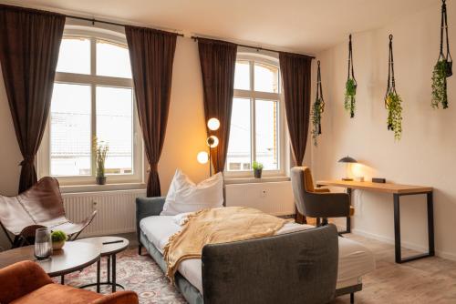 maremar - Style Apartment im Zentrum - Luxus Boxspringbett - Arbeitsplatz - Highspeed WLAN في غيرا: غرفة نوم بسرير وطاولة وكراسي