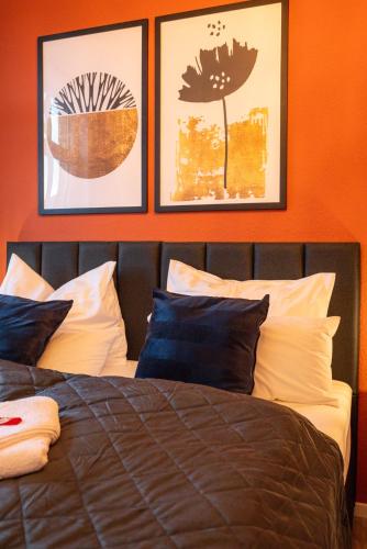 a bedroom with a bed with three pictures on the wall at maremar - Style Apartment im Zentrum - Luxus Boxspringbett - Küche - Arbeitsplatz - Highspeed WLAN in Gera
