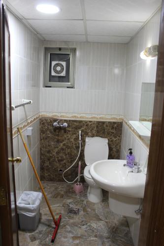 a bathroom with a toilet and a sink at الأحفاد للشقق الفندقية Al Ahfad Hotel Apartments in Şāfūţ