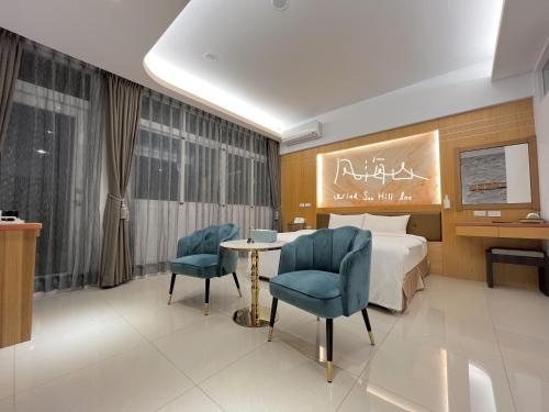 a hotel room with a bed and a table and chairs at Wind Sea Hill Inn in Hengchun