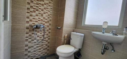 ein Badezimmer mit Toilette und Waschbecken in der Unterkunft Apartemen Student Castle Yogyakarta in Seturan