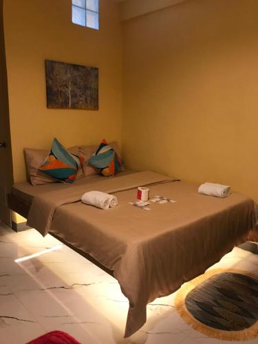 um quarto com uma cama com duas almofadas em Elmo’s place em El Nido