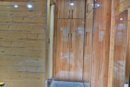 um armário de madeira com uma parede de madeira em Aasariya Hotel And Restaurants em Srinagar
