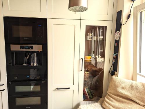 a kitchen with a cupboard with a microwave at Signe Apartment in Tartu