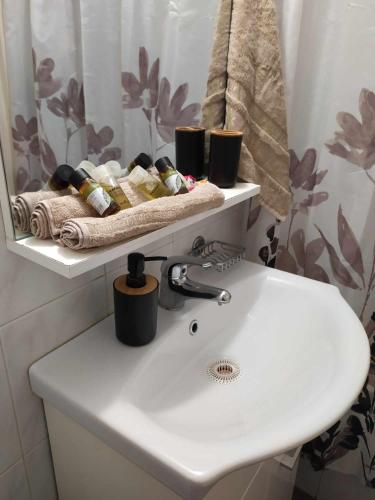 a bathroom with a white sink and a mirror at Cozy studio, 1min from Kamara in Thessaloniki