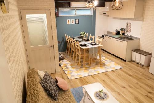 a living room with a table and a kitchen at 8人可 貸切一軒家 USJ電車14分!海遊館3駅!なんば3駅!通天閣3駅!大阪城電車15分!京セラドーム徒歩15分! 赤ちゃん子ども歓迎!Mackey's House! in Osaka
