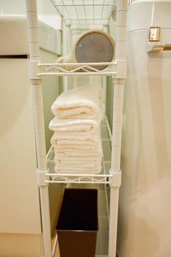 a stack of towels on a towel rack in a bathroom at 8人可 貸切一軒家 USJ電車14分!海遊館3駅!なんば3駅!通天閣3駅!大阪城電車15分!京セラドーム徒歩15分! 赤ちゃん子ども歓迎!Mackey's House! in Osaka