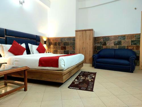 a bedroom with a bed and a blue couch at Hotel Bali Resort in Katra