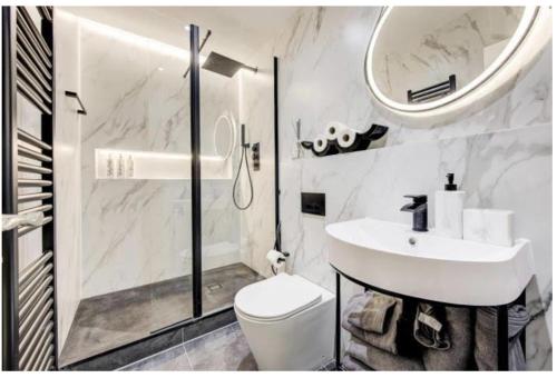 y baño con lavabo, aseo y espejo. en Stylish Apartment in the heart of Chelsea en Londres