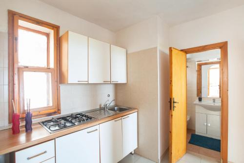 una cucina con armadi bianchi e lavandino di Centro Vacanze Piccolo Friuli a Vieste
