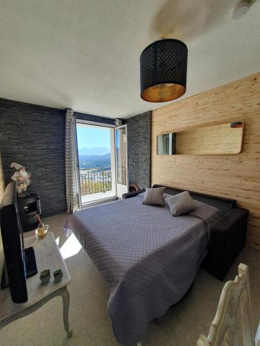 une chambre avec un lit et une grande fenêtre dans l'établissement Appartement, vue LAC Panoramique avec Terrasse, Parking, Aux Angles, aux Angles