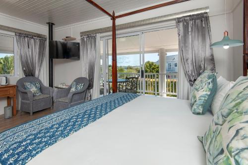 a bedroom with a large bed and a balcony at Oude Schuur Boutique Guesthouse in Hermanus