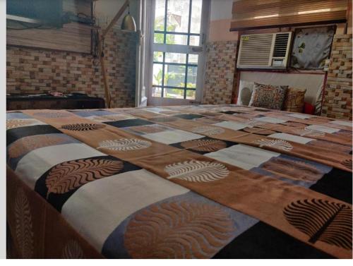 a large bed with a quilt on top of it at Simbha's Homestay in Jammu