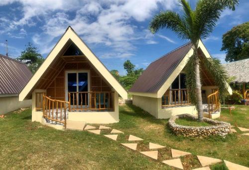 a house with a palm tree in front of it at Dwarf Guest House in Siquijor