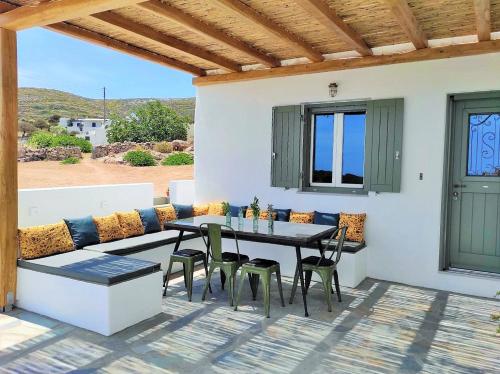a patio with a couch and a table and chairs at The old barn, Naousa Paros in Naousa