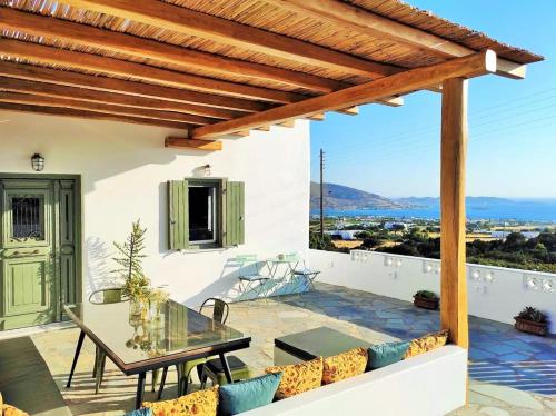 a patio with a glass table and chairs on a balcony at The old barn, Naousa Paros in Naousa