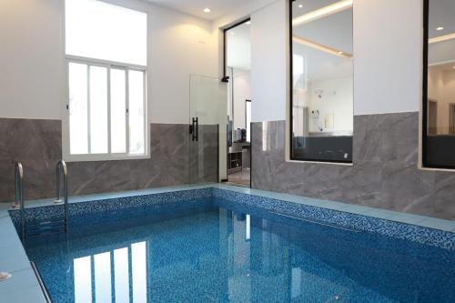 a swimming pool in a bathroom with a mirror at شاليهات صن سيت تايم in Khamis Mushayt