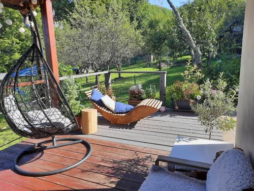 a porch with a swing and a hammock on a deck at Chata nad lázeňským údolím in Luhačovice