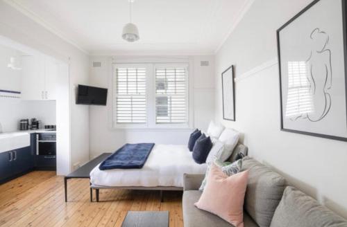 salon z kanapą i łóżkiem w obiekcie Art Deco Studio in the heart of Darlinghurst w mieście Sydney
