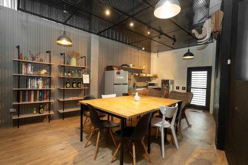 a kitchen and dining room with a wooden table and chairs at 薇薇青旅-嚞驫驛站 in Taichung