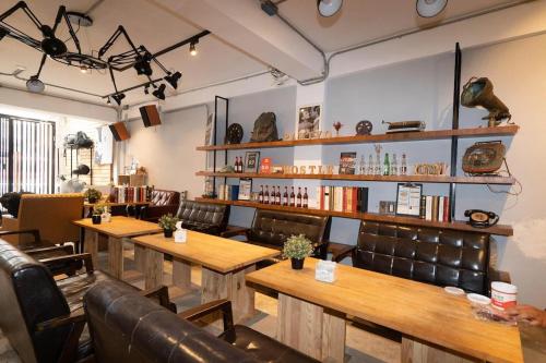 a restaurant with wooden tables and leather chairs at 薇薇青旅-嚞驫驛站 in Taichung