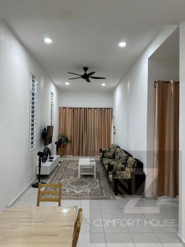 uma sala de estar com um sofá e uma ventoinha de tecto em Nz comfort house pandan kuantan em Kuantan