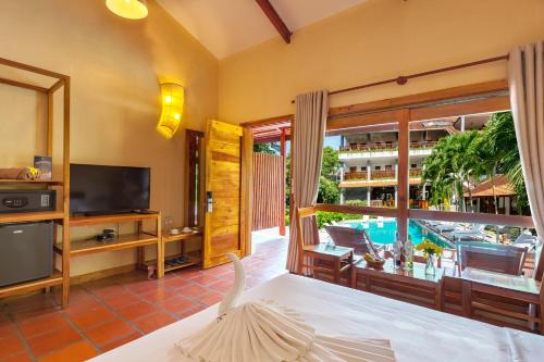 a living room with a view of a pool at Bauhinia Resort & Spa Phu Quoc in Phu Quoc