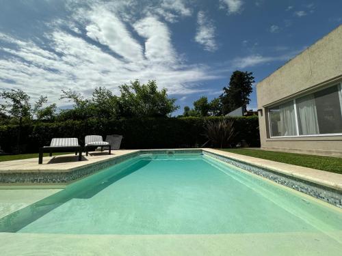 una piscina con un banco en un patio en Divina casa con parque pileta en mini barrio cerrado. en Del Viso