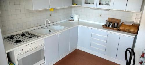 uma cozinha branca com um lavatório e um fogão em Casa bianca em Malè