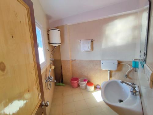 a bathroom with a sink and a toilet at Vintage Woods Inn in Shimla