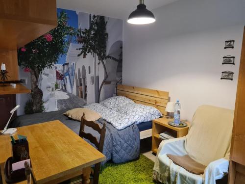 1 dormitorio con 1 cama, mesa y sillas en Apartament Bema, en Biała Podlaska