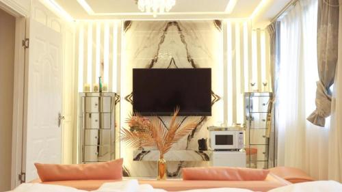 a living room with a couch and a tv on a wall at Reimi Mondo601 in Tokyo