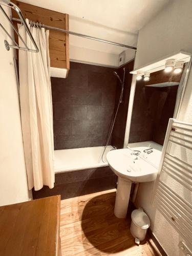 une salle de bain avec un lavabo blanc et une douche dans l'établissement Appart. 4 à 6 pers. centre Bois Méan, aux Orres