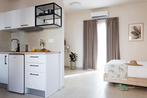 a kitchen with white cabinets and a table in a room at Limeria studios & maisonettes in Parga