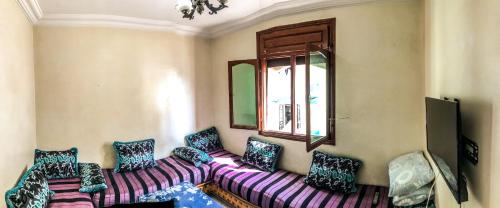 een woonkamer met een paarse bank en een raam bij Blue Beach Apartments in Taghazout