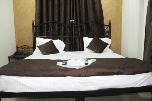 a bed with a black and white comforter and pillows at Hotel Preetam Aurangabad in Aurangabad