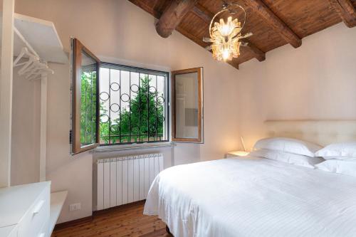 1 dormitorio con cama blanca y ventana en Amata Berghem Casa Vacanze con auto a disposizione, en Aviatico