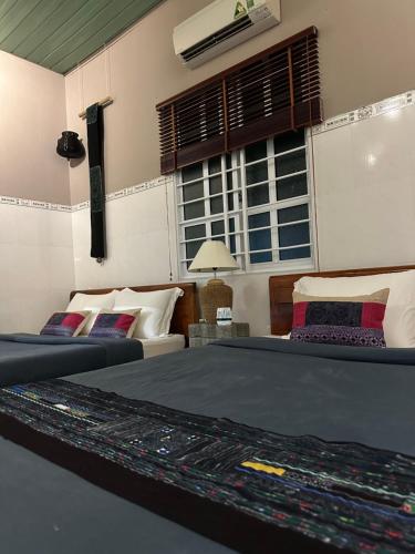 a bedroom with two beds and a window at Chang's Hideaway homestay ConDao in Con Dao