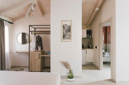 Limeria studios & maisonettes في بارغا: غرفة بجدران بيضاء وسرير أبيض في غرفة