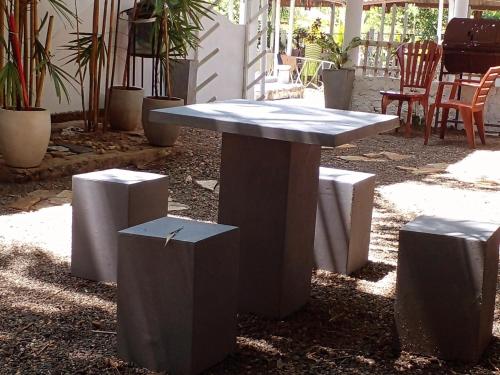 una mesa de hormigón y taburetes en un patio en Asanka Surf House & Resturant, en Midigama East