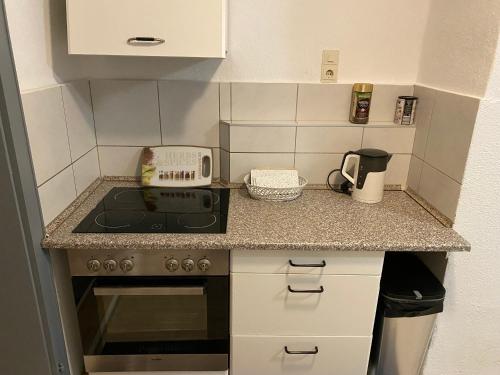 a small kitchen with a stove and a microwave at Hannover-Ronnenberg EG in Ronnenberg