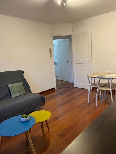 ein Wohnzimmer mit einem Sofa und einem Tisch in der Unterkunft Dinan - appartement centre ville in Dinan