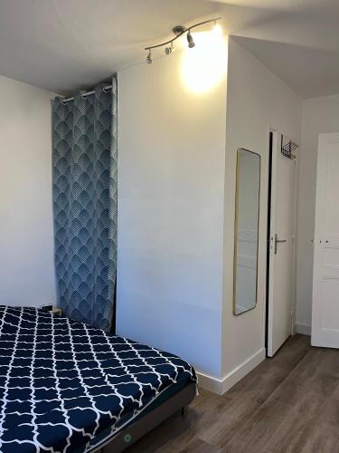 une chambre avec un lit et un miroir au mur dans l'établissement Dinan - appartement centre ville, à Dinan
